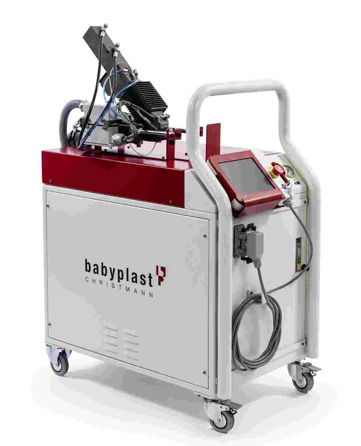 Ein babyplast Zusatz-Spritzaggregat auf einem fahrbaren Steuerschrank mit Touch-Display, Not-Aus-Schalter und Bügelgriff.
